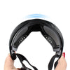 A hand holds a black durable dog eye protection sunglasses with blue light emanating from the lens.
