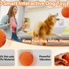 An orange interactive dog toy ball being played with by a happy dog on a sofa.