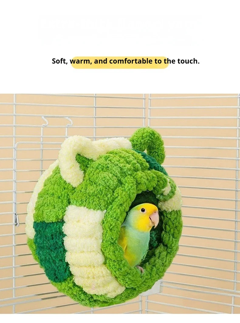 Ein flauschiges grün-weißes Flanellvogernest in einem Drahtkäfig.