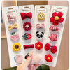 A display of five pink and red flower-shaped baby hair clips on white cardboard packaging.
