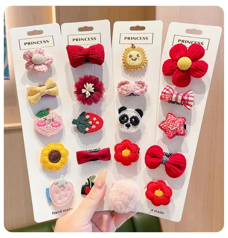 A display of five pink and red flower-shaped baby hair clips on white cardboard packaging.