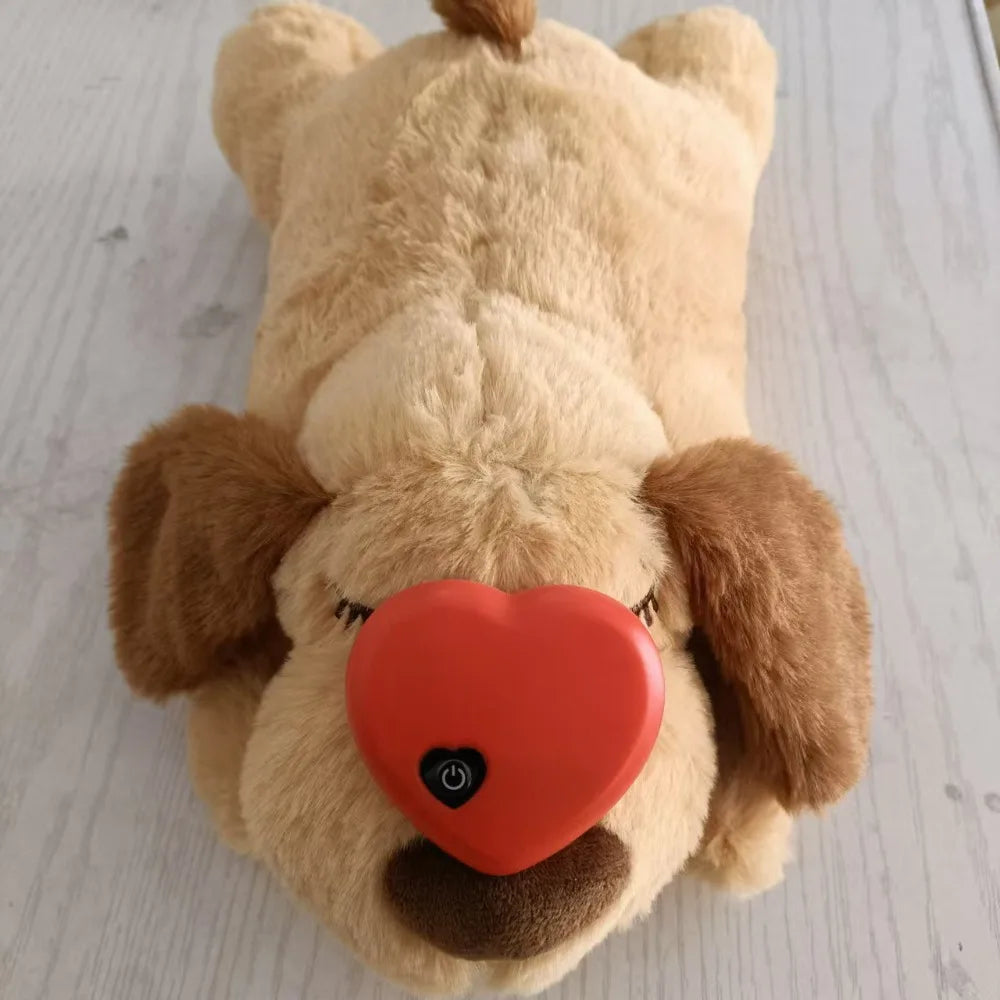 A light tan plush comfort toy shaped like a dog's head with floppy ears and a large orange heart on its face.