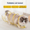 A fluffy gray and white cat is playing inside a yellow foldable cat tunnel for indoor play.