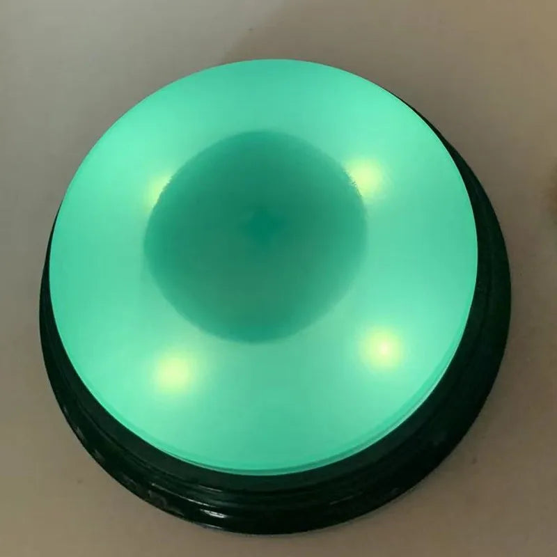 A round, teal-colored button used for dog training.