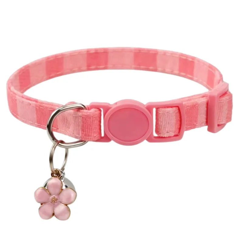 A pink and white striped collar with a pink bow pendant for a cat.