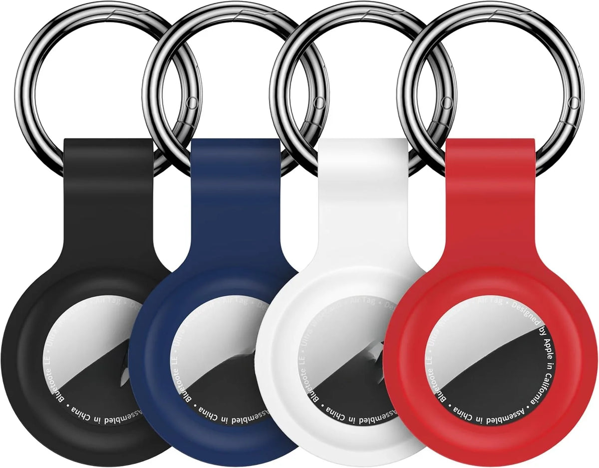 A set of silicone airtag protective covers in black, blue, white, and red attached to metal keychains.
