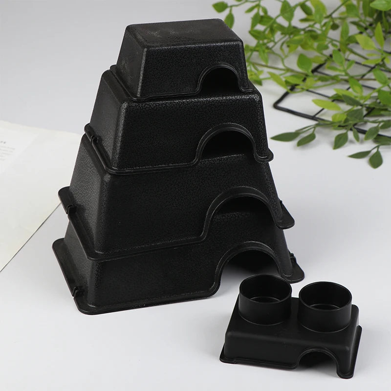A stack of black reptile and small animal hide boxes on a white surface.