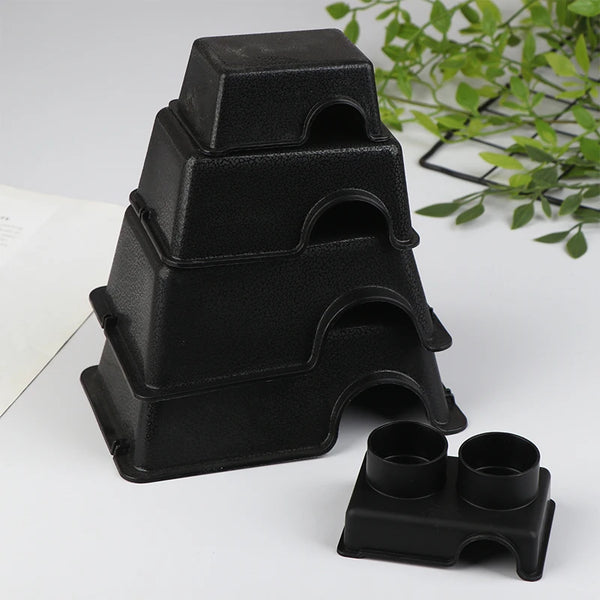 A stack of black reptile and small animal hide boxes on a white surface.
