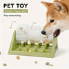A dog is interacting with a green puzzle feeder toy designed to rotate freely and play while eating.