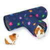 A dark blue fabric pet tunnel with colorful stars is shown next to a small orange and white guinea pig.