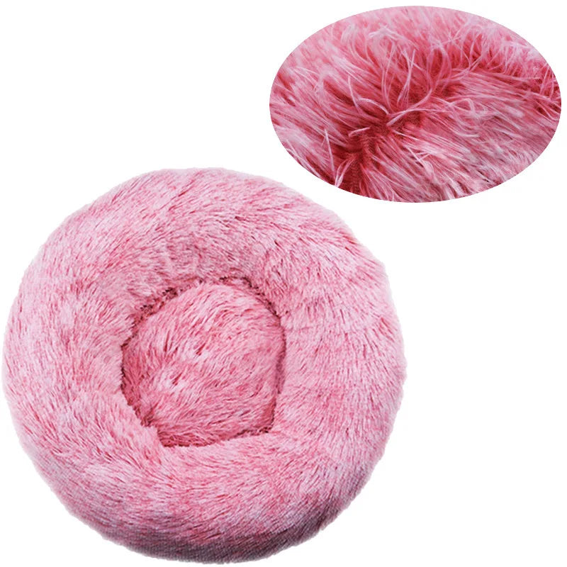A pink plush round pet bed with a removable washable cover, shown from above.