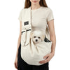 A woman is holding a beige crossbody pet carrier bag designed for dogs and cats.