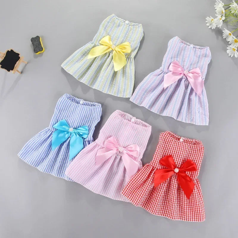 A collection of pink, yellow, blue, and red striped bow dresses for small pets.