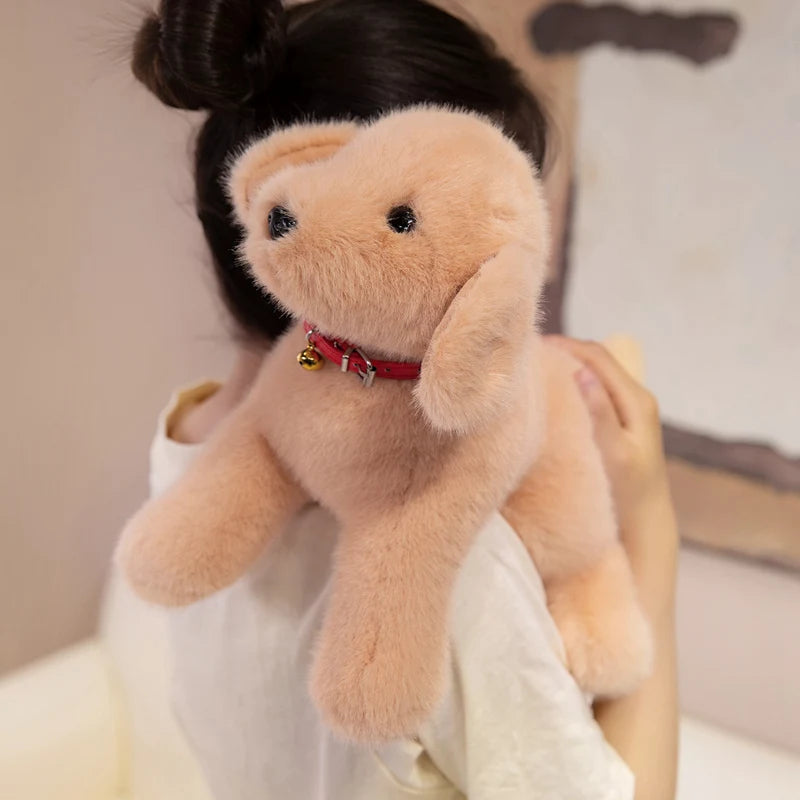 A soft, light peach-colored plush dog toy resembling a Golden Retriever with a red collar.