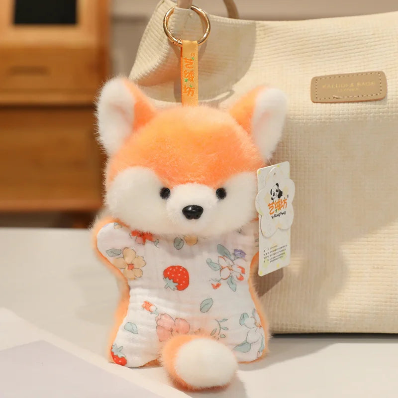 An orange and white fox-like cartoon plush toy with large ears is hanging from a gold-colored tag.