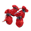 A pair of red cozy anti-slip dog booties with gray reflective grips.