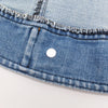 Close-up of a classic blue denim dog jacket showing the fabric texture and a silver D-ring attachment.