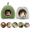 A green plush cave bed with an entrance showing a small brown hamster inside, surrounded by various small rodents.