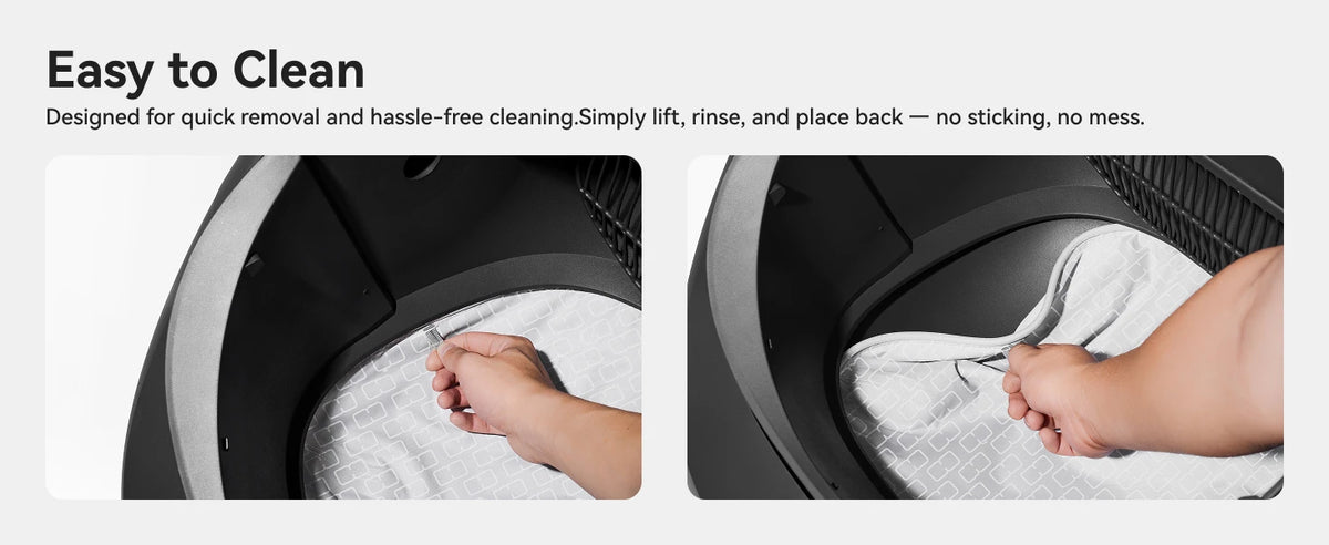 A hand is shown lifting a white cloth mat from the interior of a black litter box.