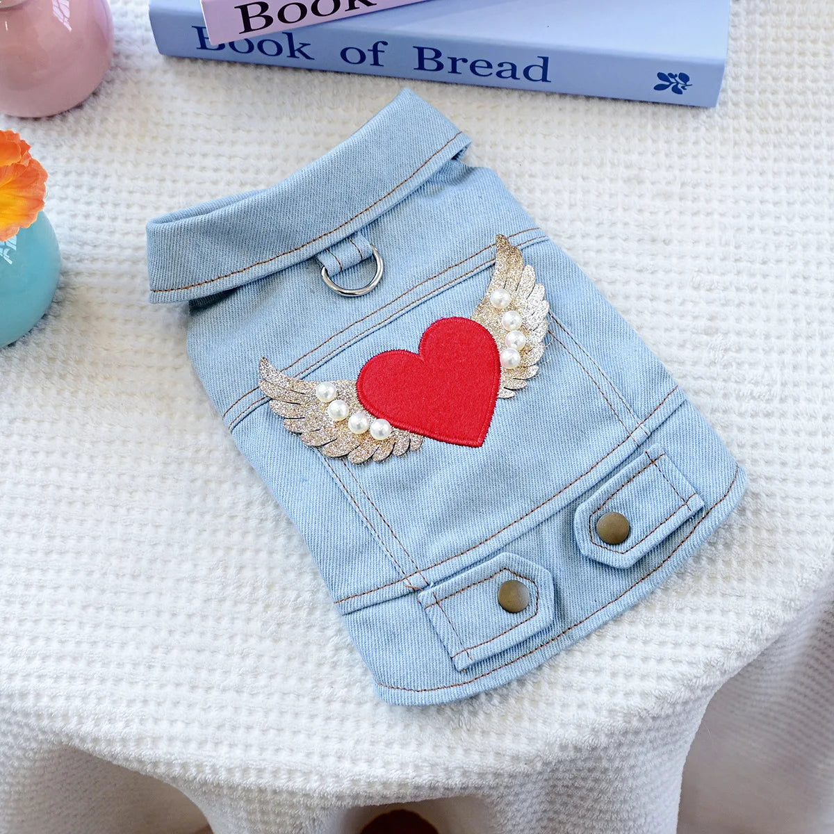 Light blue denim jacket for dogs featuring a red heart and gold feather embroidery