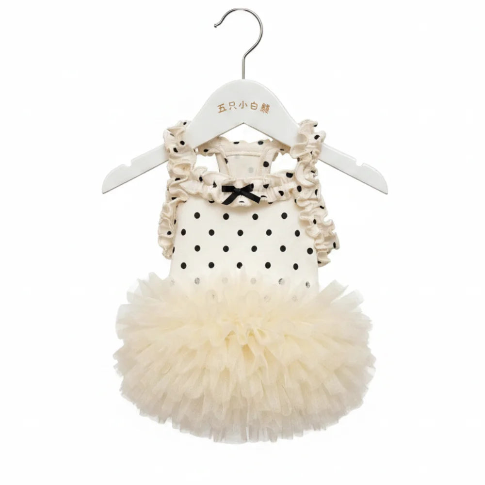 Weißes Slipkleid mit schwarzen Polka Dots und Rüschen, auf weißem Bügel.