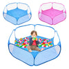 A foldable transparent pet playpen with pink and blue sections, shown assembled and in use by a child.