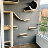 Wall-mounted cat climbing shelves featuring a hammock and scratching post mounted on a gray wall.