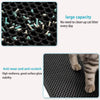 Close-up view of a black honeycomb cat litter mat showing small white and blue litter particles on the surface.