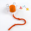 An orange training ball with a string attached, used for automatic cat and dog training.