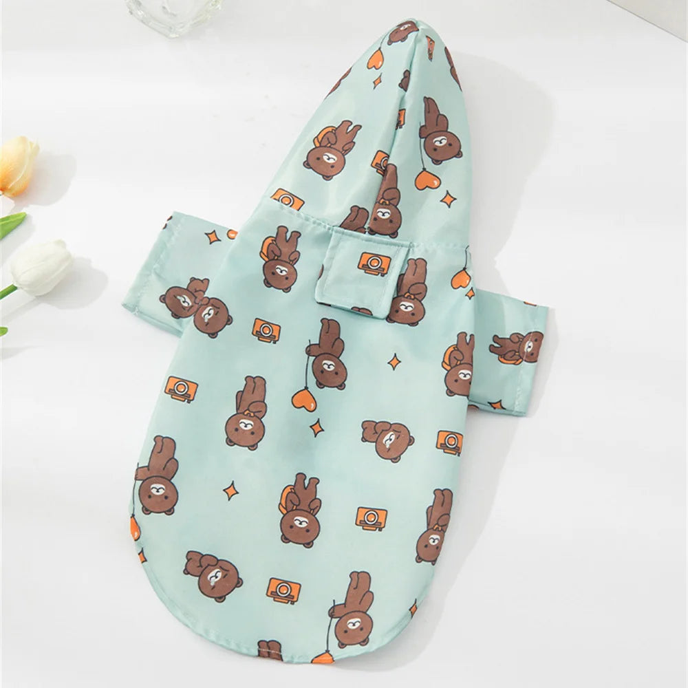 A light teal cartoon printed raincoat featuring small brown dog illustrations and orange accents.