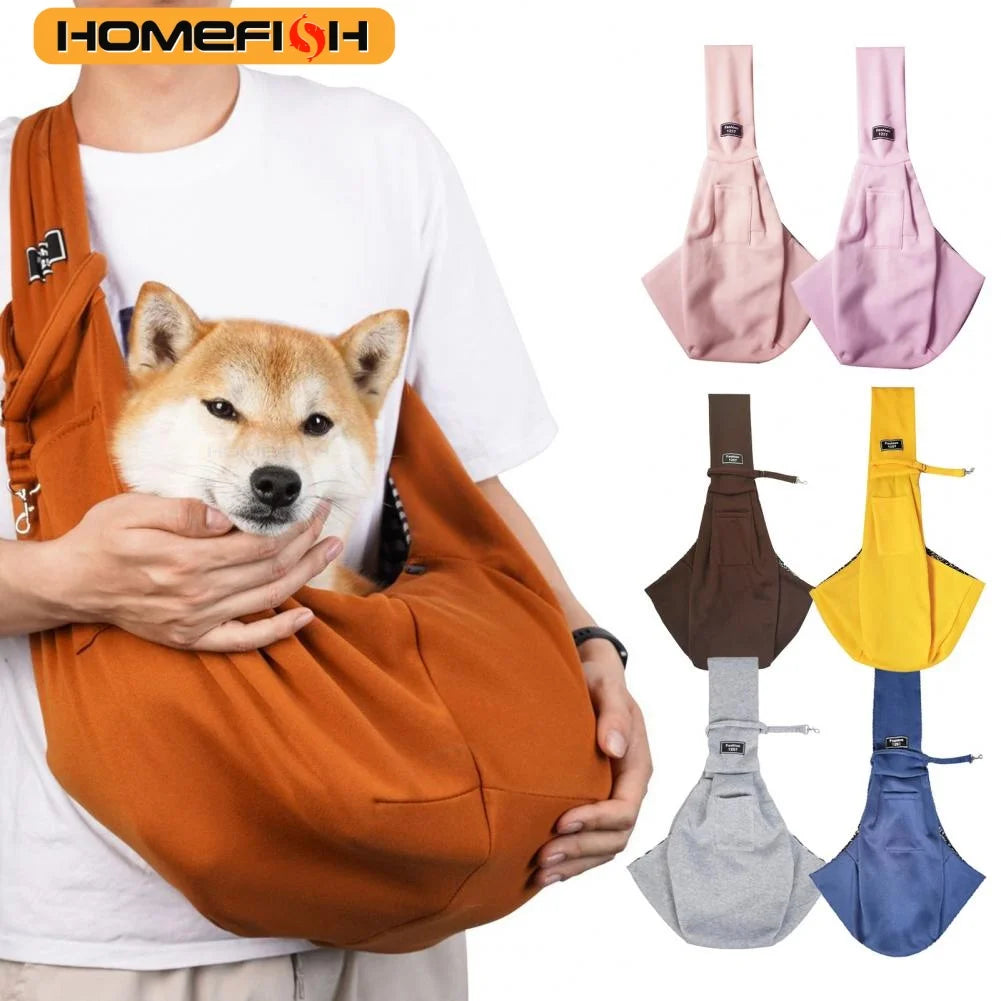 A person is holding an orange adjustable crossbody dog sling carrier with various colored fabric options.