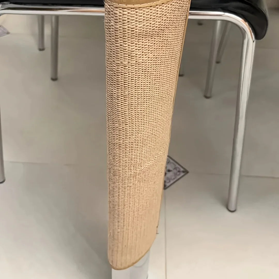 A close-up view of a cylindrical cat scratch board made of woven natural fiber, positioned on a metal furniture leg.