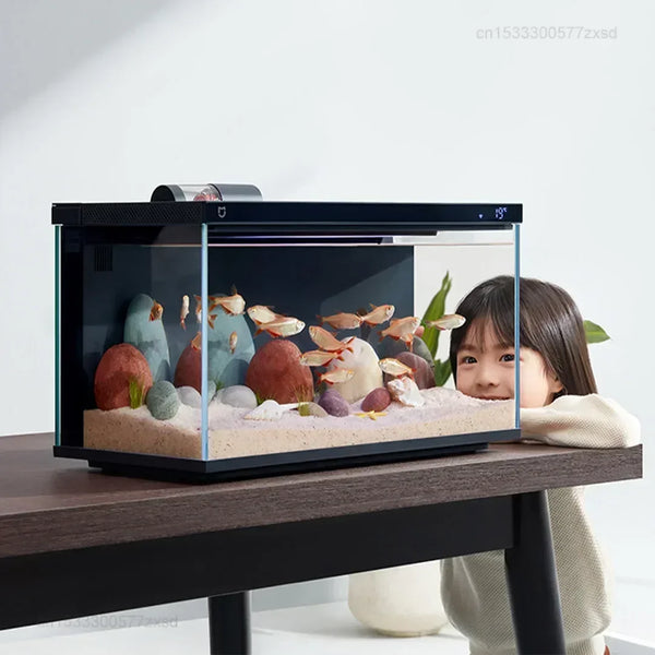 A black smart aquarium tank is displayed on a wooden table, featuring colorful fish and decorative elements.