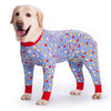 A golden retriever wearing a blue jumpsuit with a cartoon animal print featuring ice cream motifs.