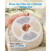 A hand is rinsing a white activated carbon filter disc under running water before use.