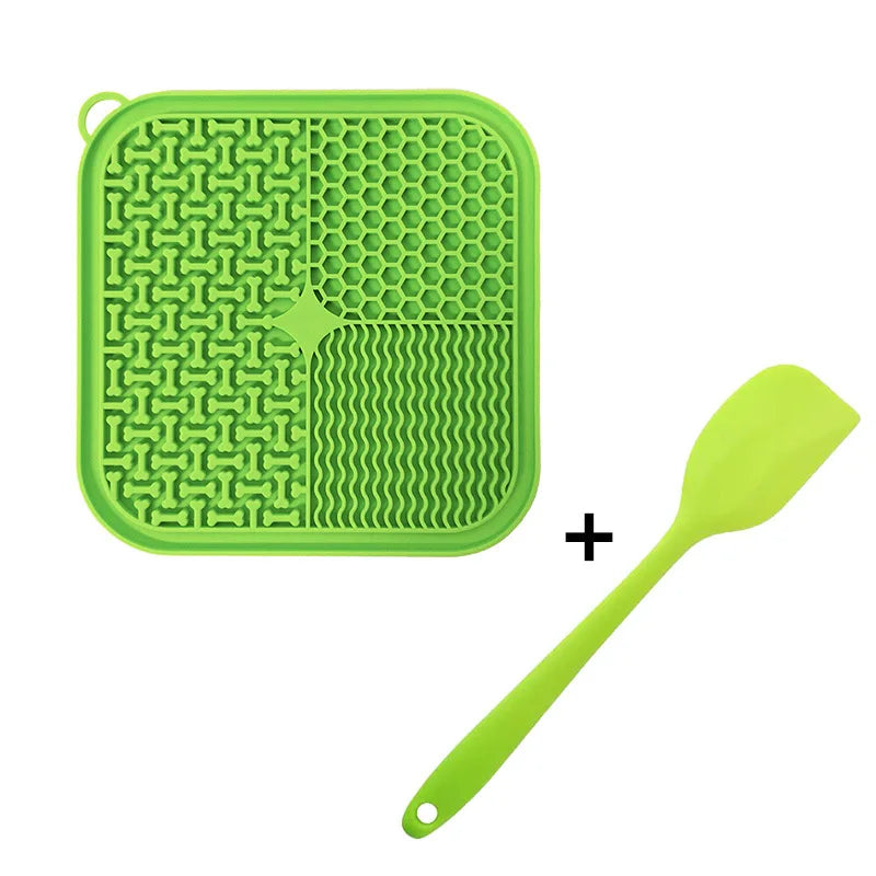 A bright lime green silicone licking mat for pets with suction cups and a matching yellow silicone spoon.
