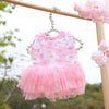 Vestido de encaje de gasa rosa para perros y gatos colgado en un marco de madera