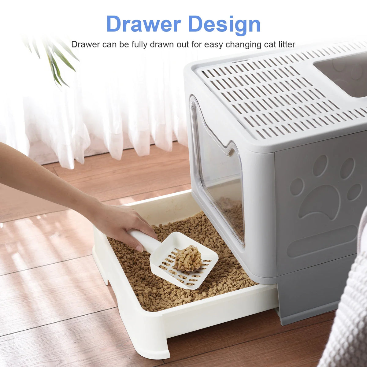 A hand is drawing out the drawer of a white cat litter box, showing its design for easy changing.