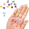 A hand displays various colorful luminous resin turtle ornaments in different sizes and colors.