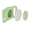 A silicone airtag holder in light green, showing the main body and a separate circular piece.
