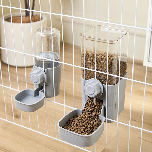 A pet feeder with two compartments is shown inside a wire cage, feeding kibble to a dog or cat.