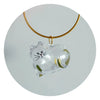 A clear glass heart shaped charm featuring a cat face and green hair, suspended from a gold-colored cord.