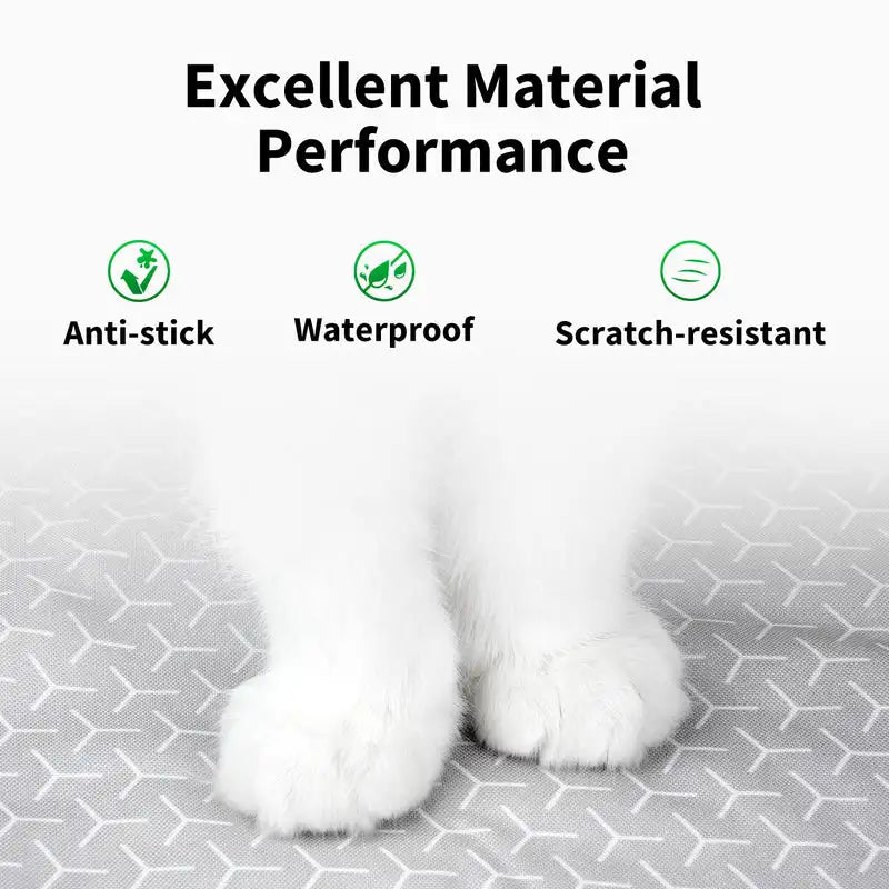 White cat paws resting on a gray surface, demonstrating anti-stick, waterproof, and scratch-resistant material performance.