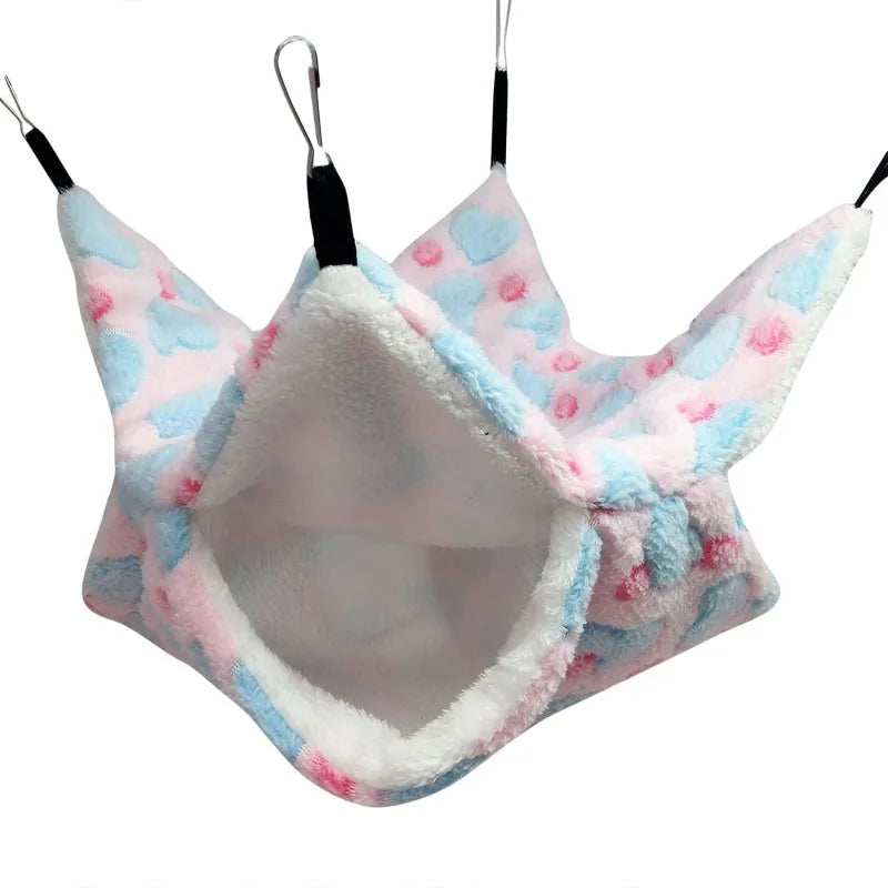 A pink and blue fleece double layer hammock bed for hamsters, hanging by strings.