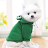 Ein weißer Hund trägt einen grünen, froschförmigen Hoodie für Cosplay.