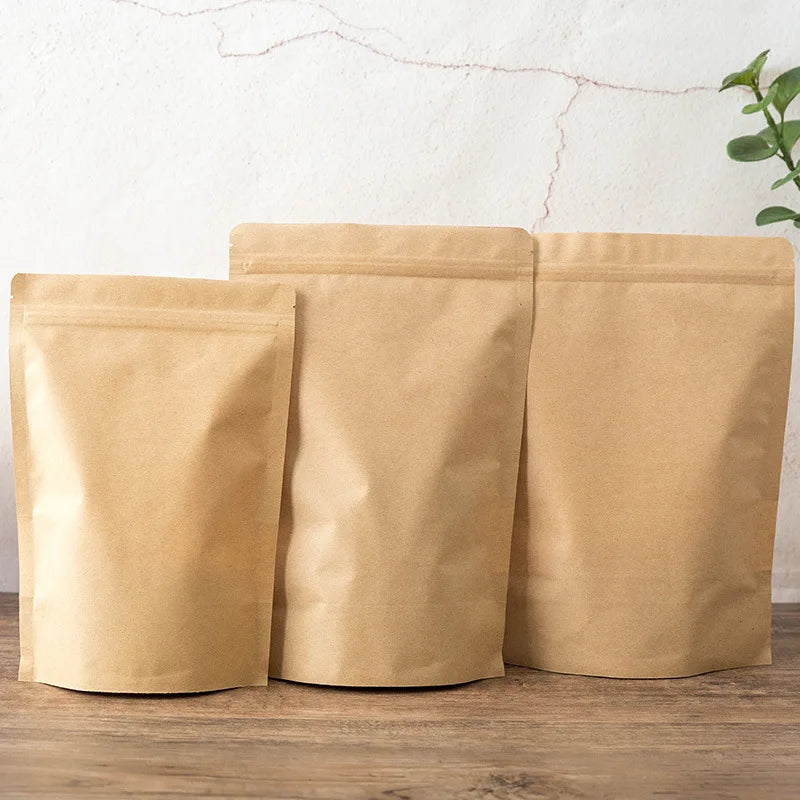 Three kraft paper zipper bags stacked side by side on a wooden surface.