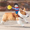 A dog wearing a funny cowboy costume jacket and a yellow hat is running on a wooden floor.