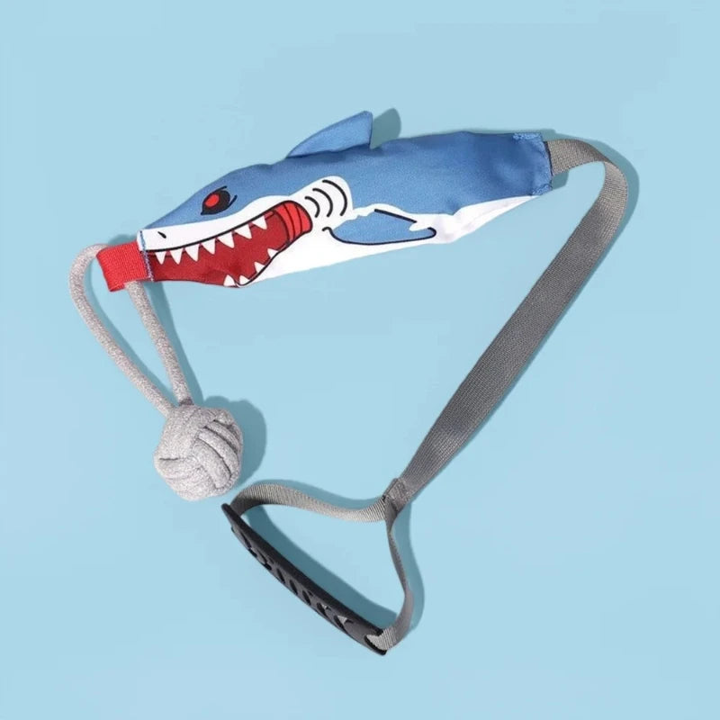 A blue and white shark-themed dog tug-of-war rope toy with a gray strap and a knotted end.