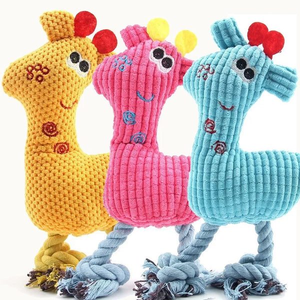 Three knitted plush toys shaped like giraffes in yellow, pink, and blue with dangling feet