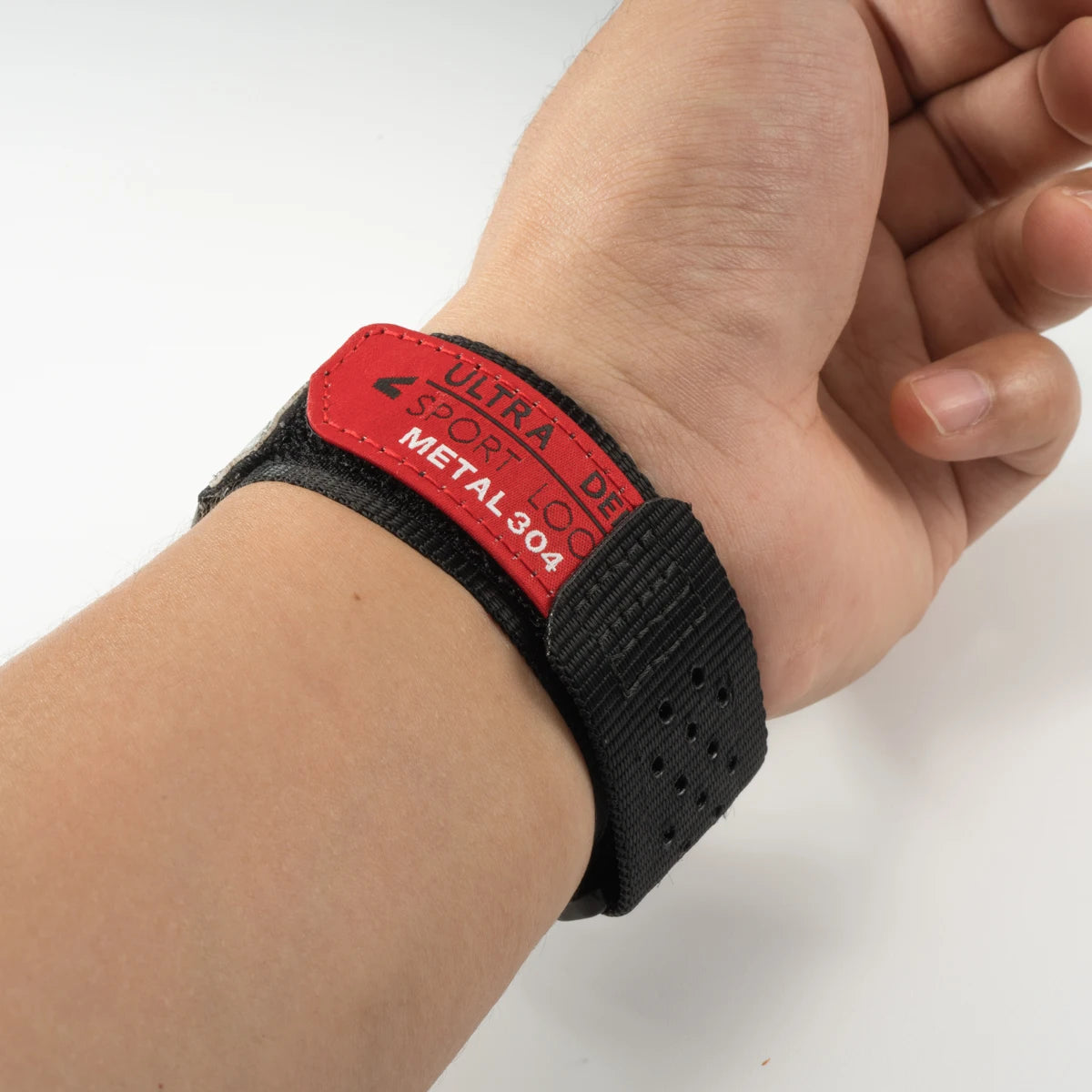 A black silicone sport band with a red label marked ULTRA SPORT METAL 304 is shown on a wrist.